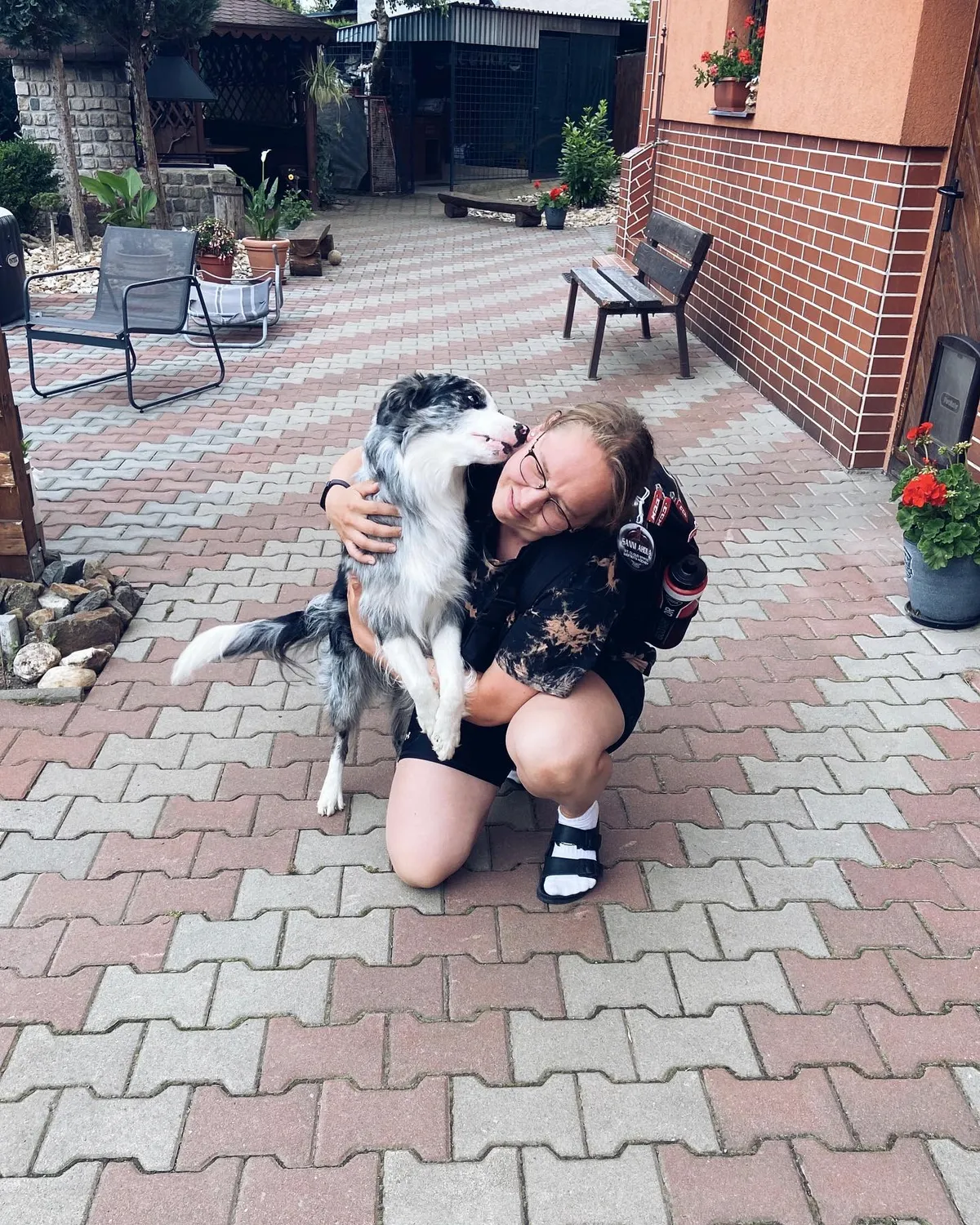 Sanni Ahola off the ice, hugging a border collie with her hockey bag on